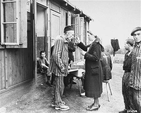 A sick Polish survivor in the Hannover-Ahlem subcamp receives medicine from the Red Cross, 11 April 1945